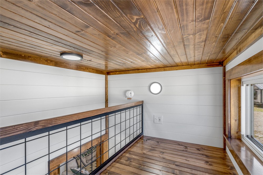 Tinde upper loft with timber ceiling and black railing