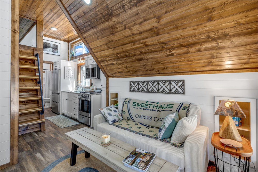 Tinde living area with sofa beneath sloped timber ceiling