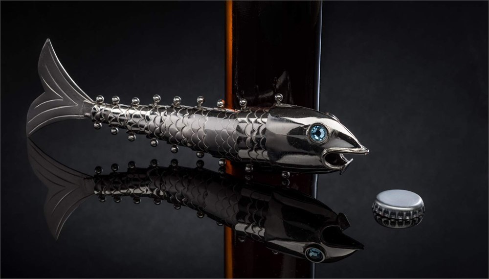 Chrome fish bottle opener beside a removed bottle cap