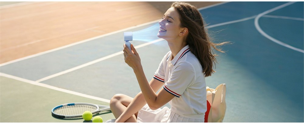 Blue personal fan used beside a tennis court