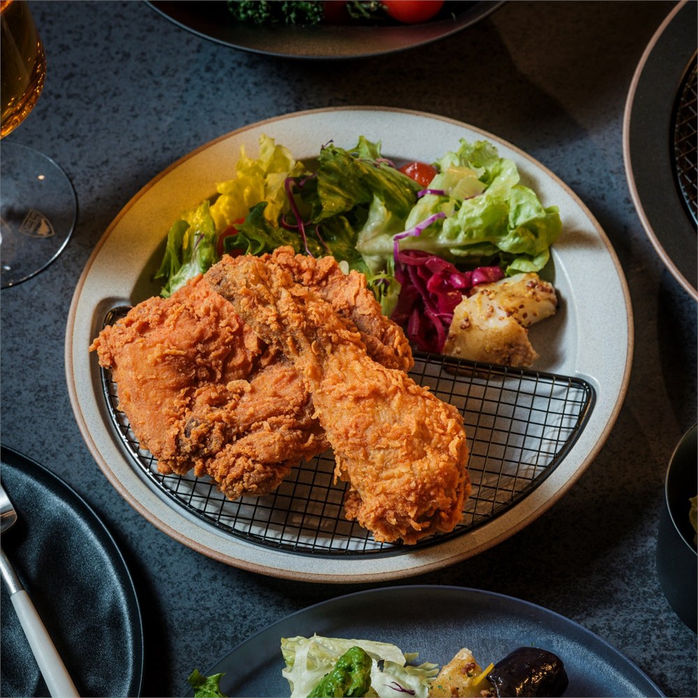 Light gray Half-Moon Plate with fried chicken on the mesh rack and salad beside it