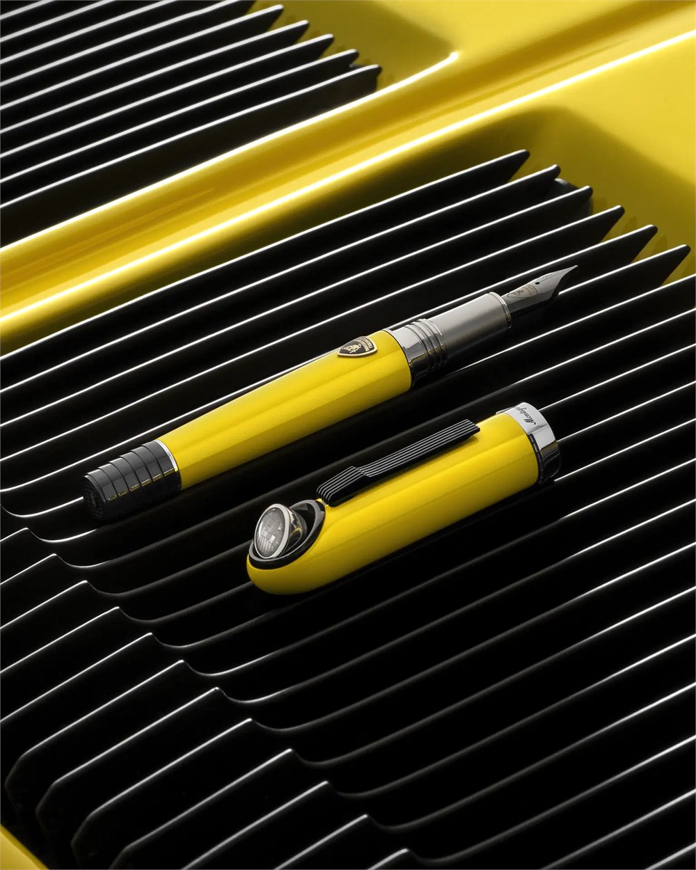 Yellow fountain pen and cap on a black engine grille