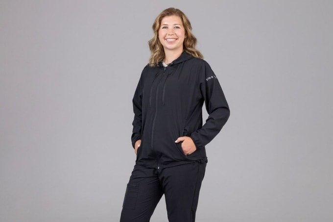 Woman wearing the black full-zip travel jacket and matching joggers