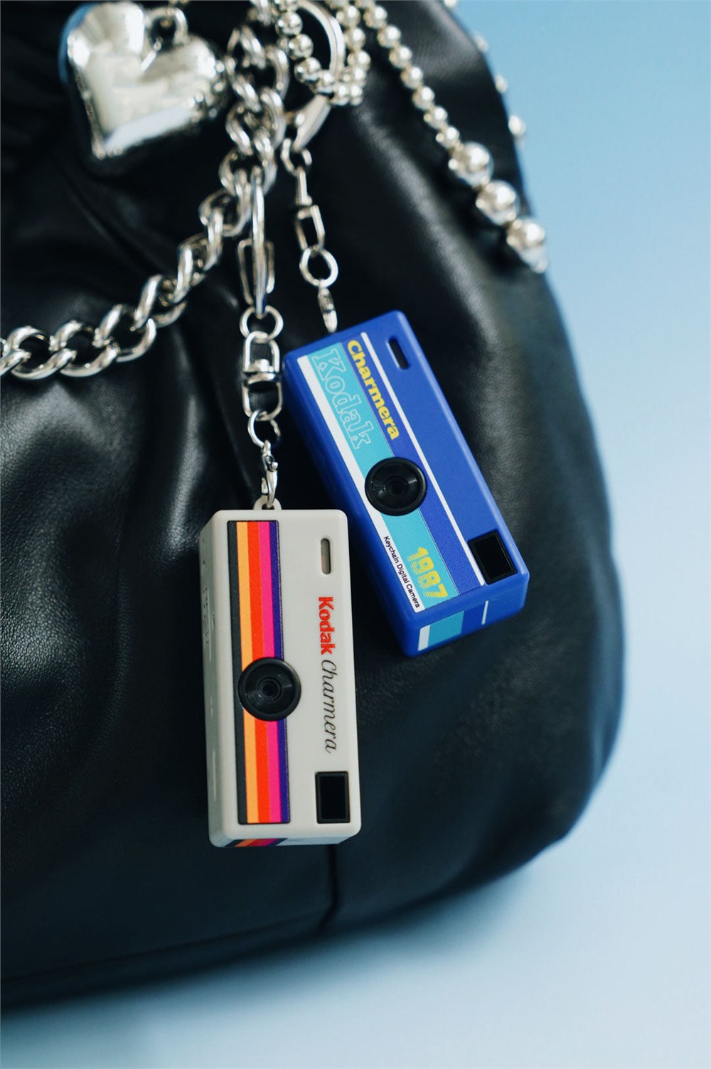 Two Charmera miniature cameras attached to a bag