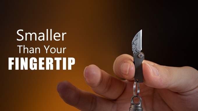 TIKZER G11 miniature knife held between fingertips