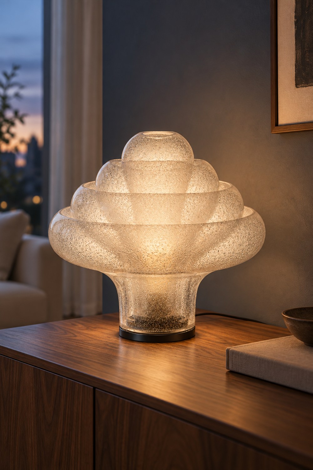 Illuminated GUBI Lotus table lamp with four nested bubble-glass shades and a black chrome base on a walnut sideboard at dusk.