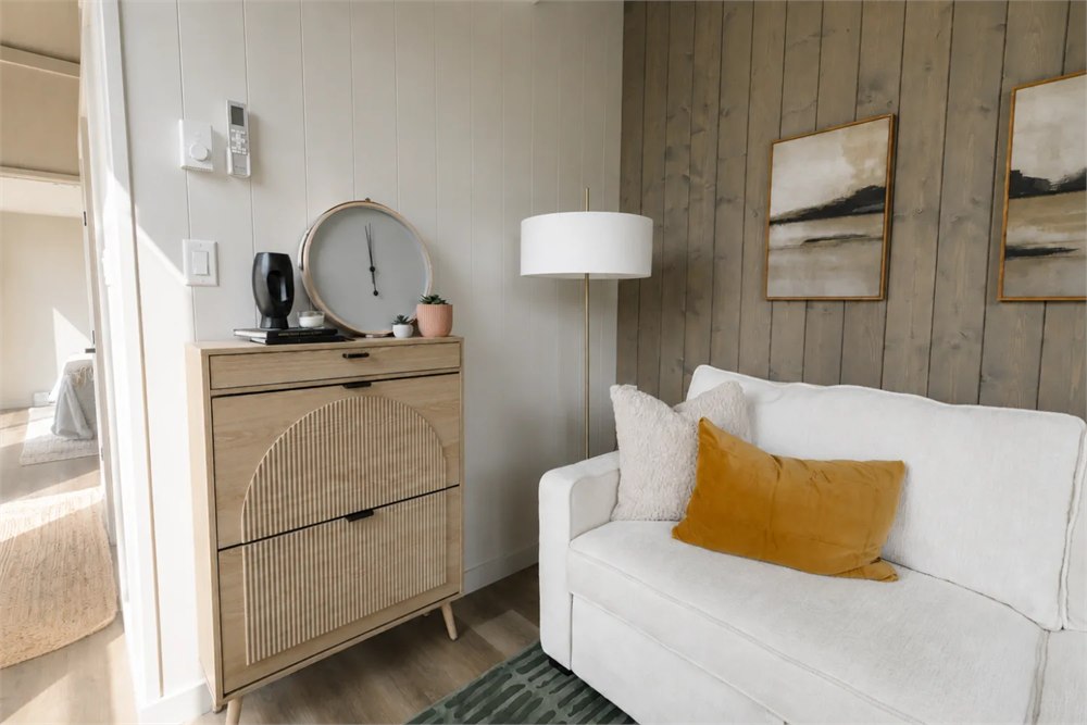 Ventura living area with a sofa and warm wood accent wall