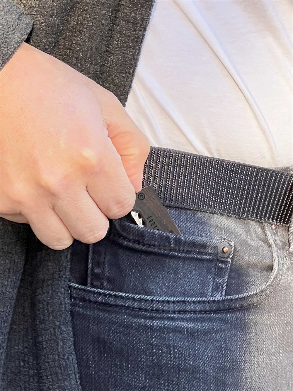 Edge & Pop knife being placed into the front pocket of dark blue jeans to show pocket carry.