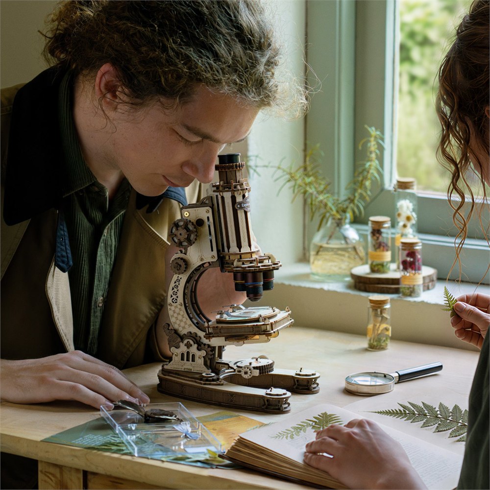 Two people examining specimens with the microscope