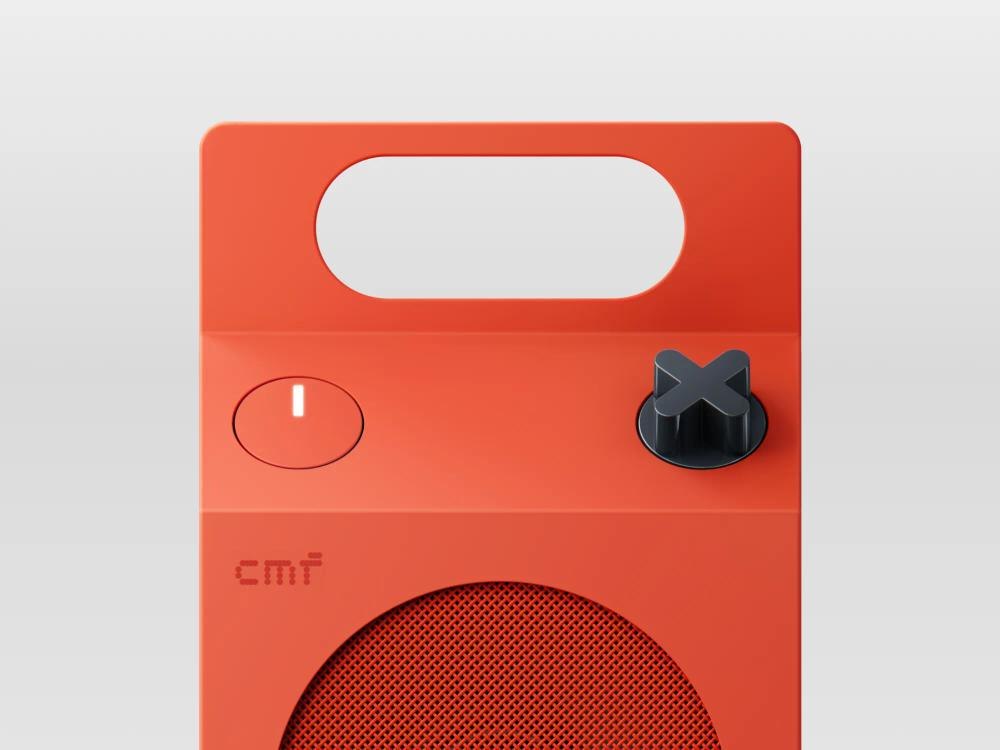 Close view of orange speaker handle power button and X-shaped knob