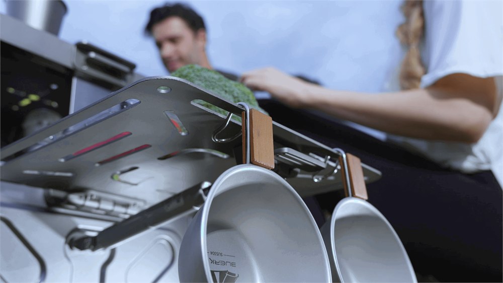 Cookware hanging from the modular camp kitchen rails