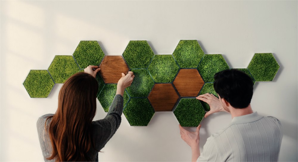 Two people arranging Moss Hexa panels on a wall