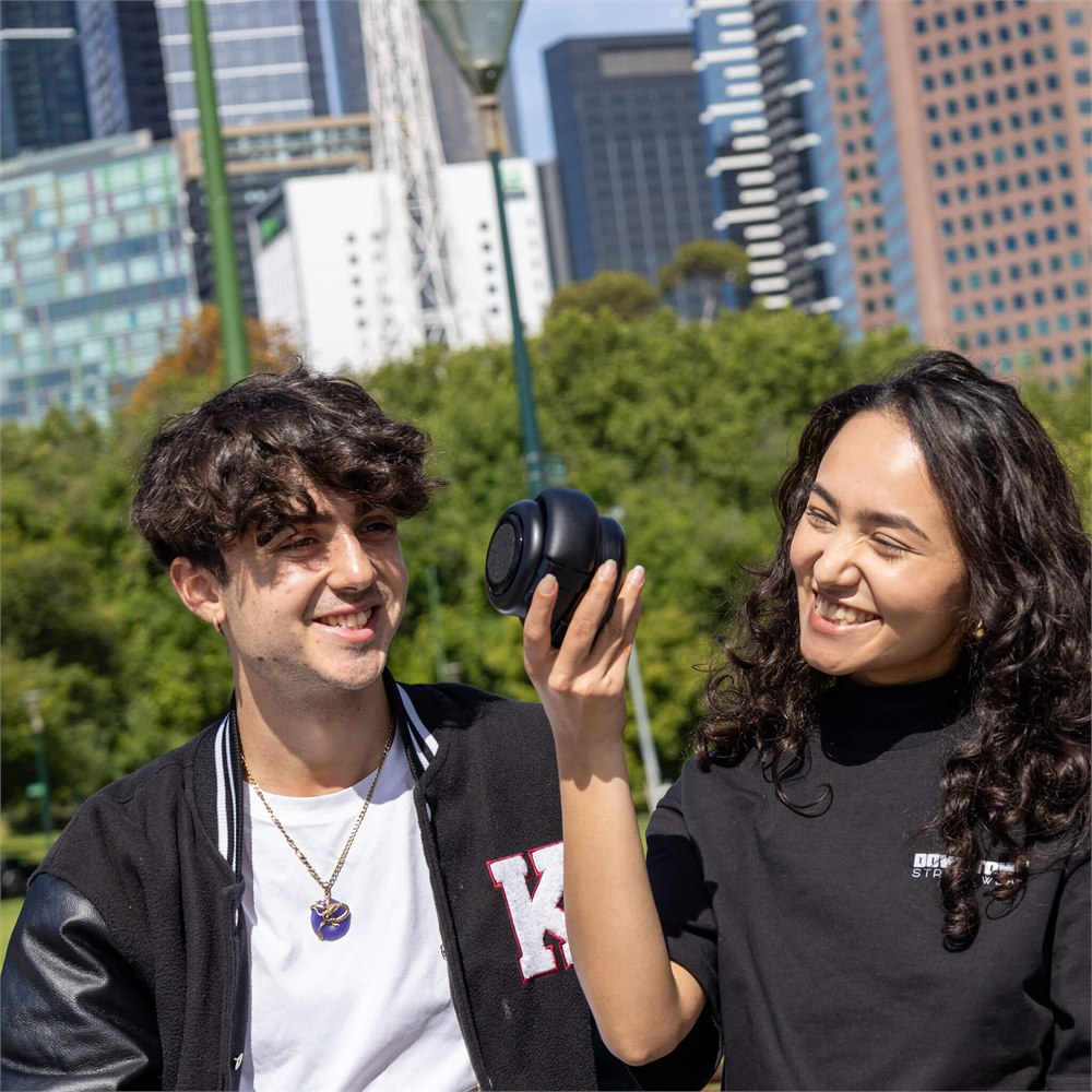 Two people sharing music with the compact TDM Neo speaker