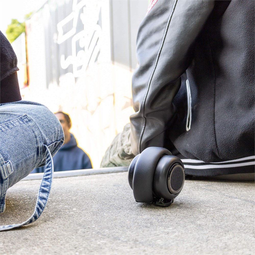 TDM Neo speaker beside a backpack on an outdoor step