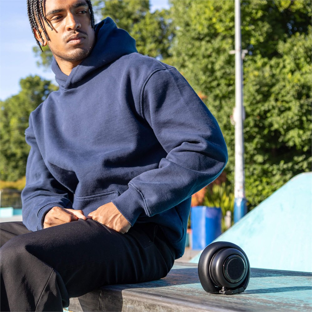TDM Neo speaker resting beside a seated listener outdoors