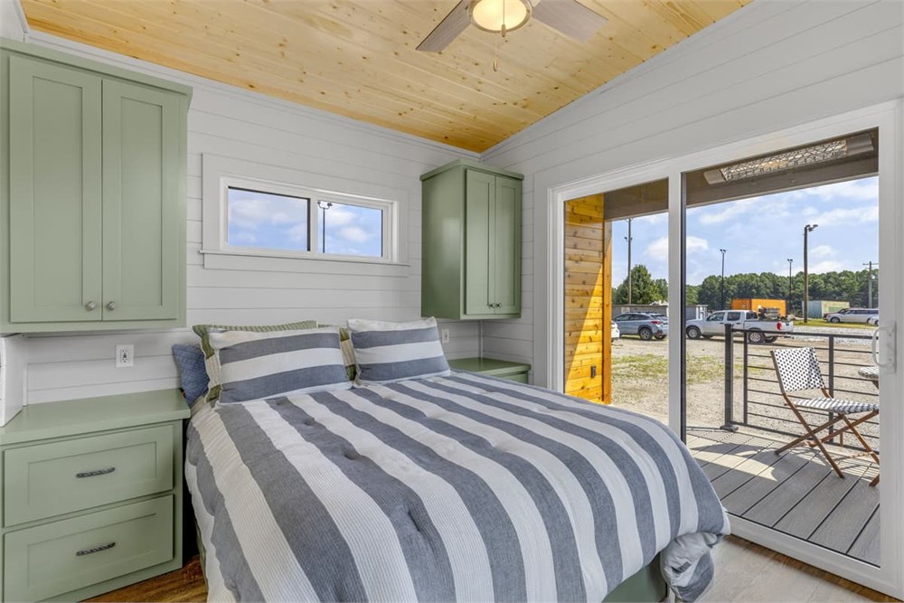 Main-level bedroom with storage and glass door to the rear porch