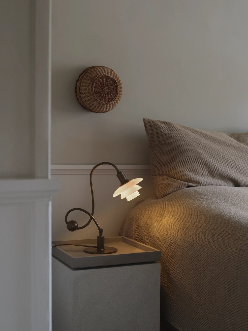Adjustable piano table lamp beside a bed