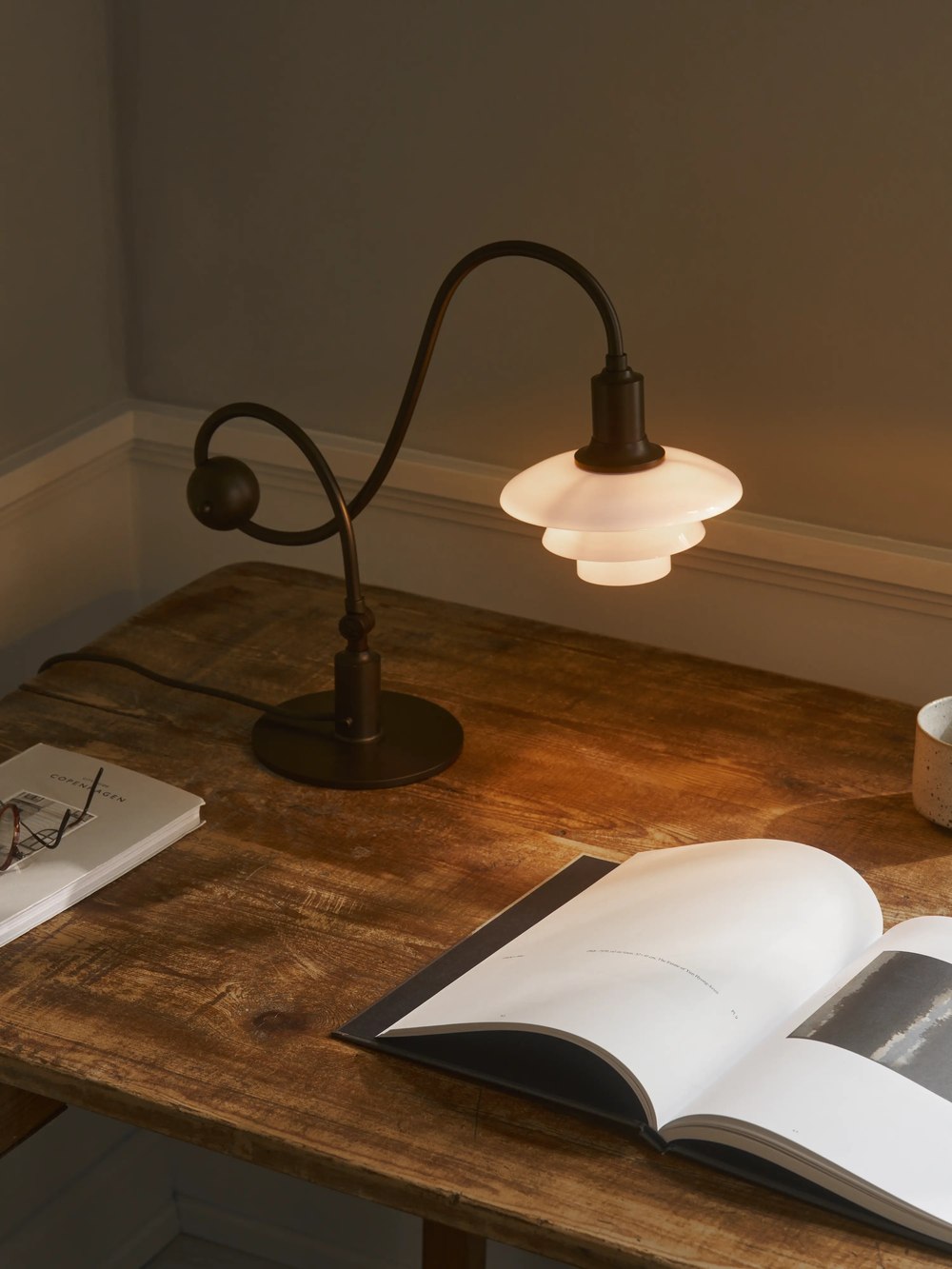 Piano table lamp illuminating an open book