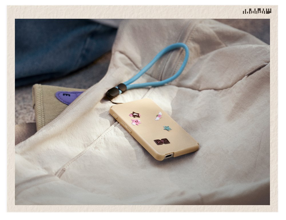 Back of a decorated Picco case with a wrist strap on a bag