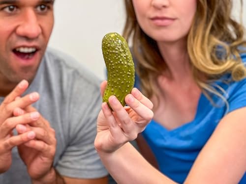 Two people holding and reacting to the green Mystic Pickle toy