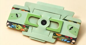 Foldscope 2.0 mint green folded pocket microscope on a cream background