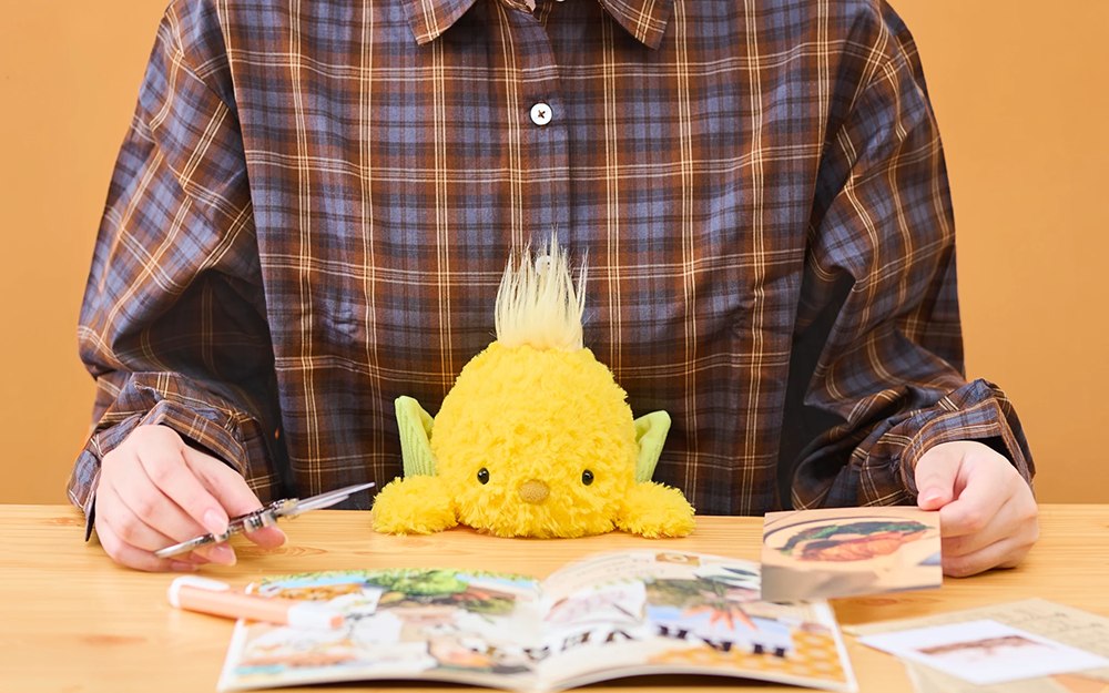 Corn posture plush at a desk during paper crafts