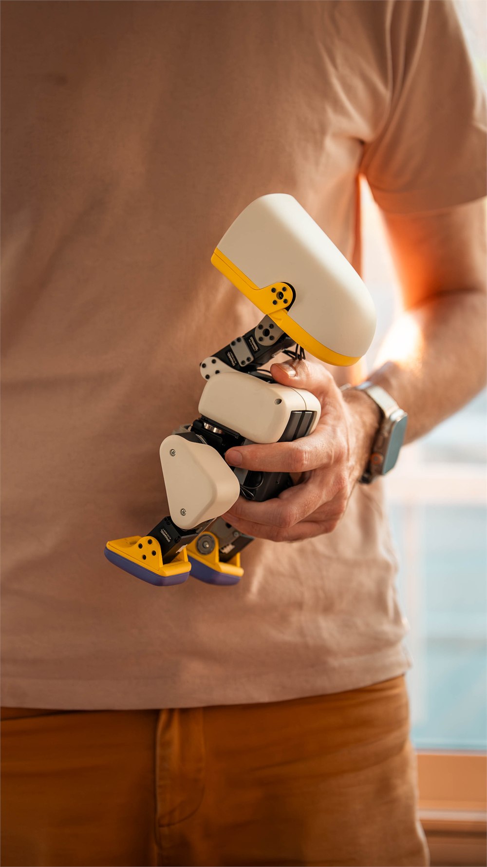 Microduck robot carried under a person's arm