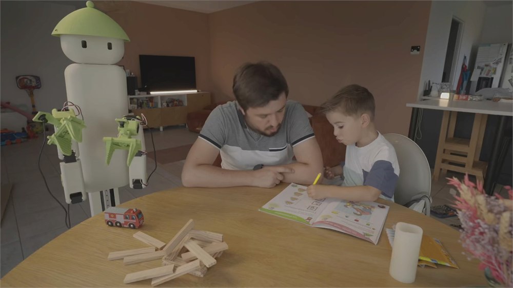 Flourish robot beside a father and child at a table
