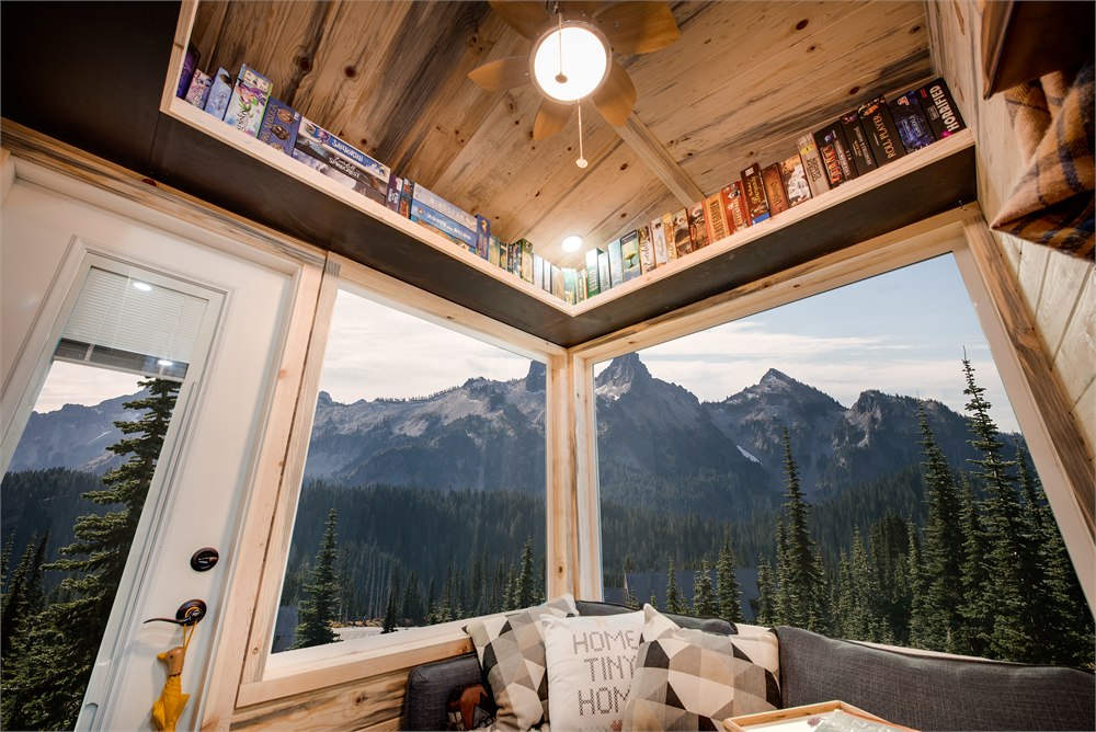 Corner windows and overhead shelves in the tiny house living area