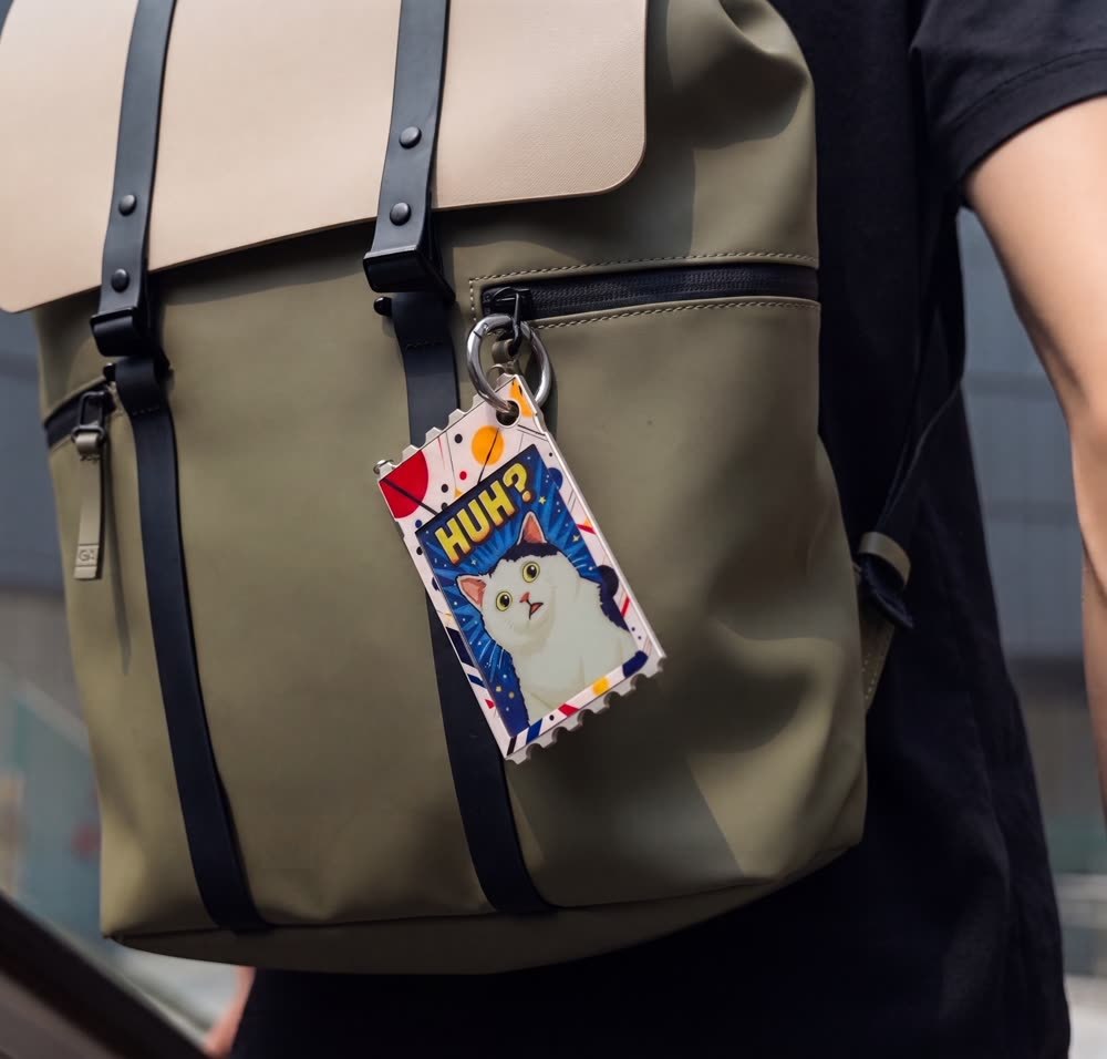 TICKEY display attached to an olive backpack with a metal ring