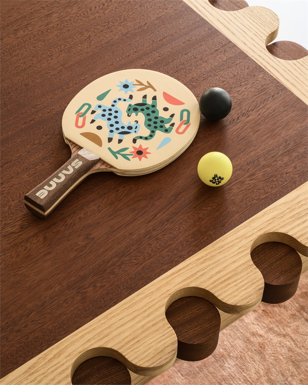 Illustrated paddle beside the scalloped wood tabletop edge