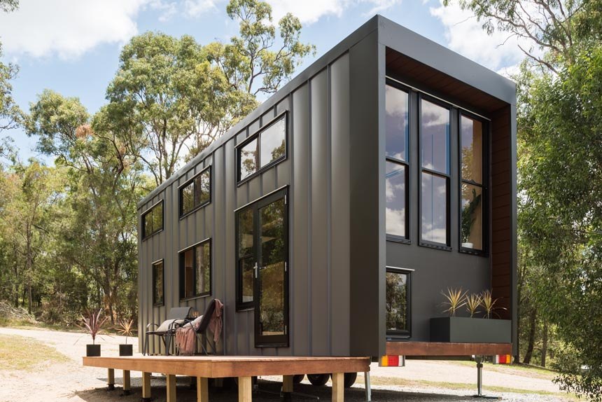 Wildscape tiny house exterior with tall windows and metal cladding
